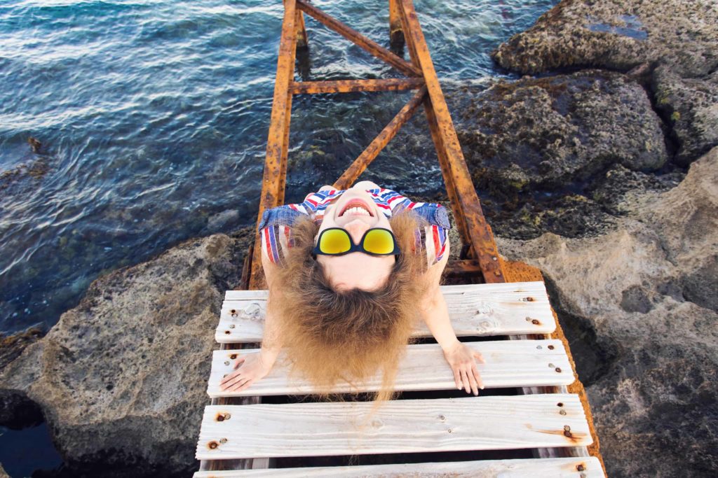 young happy woman sitting on wooden pier and PYVZBCY e1549039038927 1024x683 - What You Focus On Expands